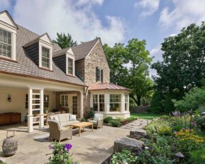 stone house with flagstone patio and flowering garden