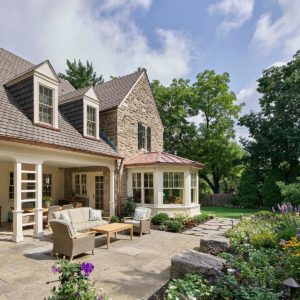 stone house with flagstone patio and flowering garden